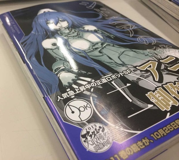 『シドニアの騎士』11巻のオビ左上にある「OK」という文字が入っているのが同人マーク／画像はWebサイト「アフタヌーン」より